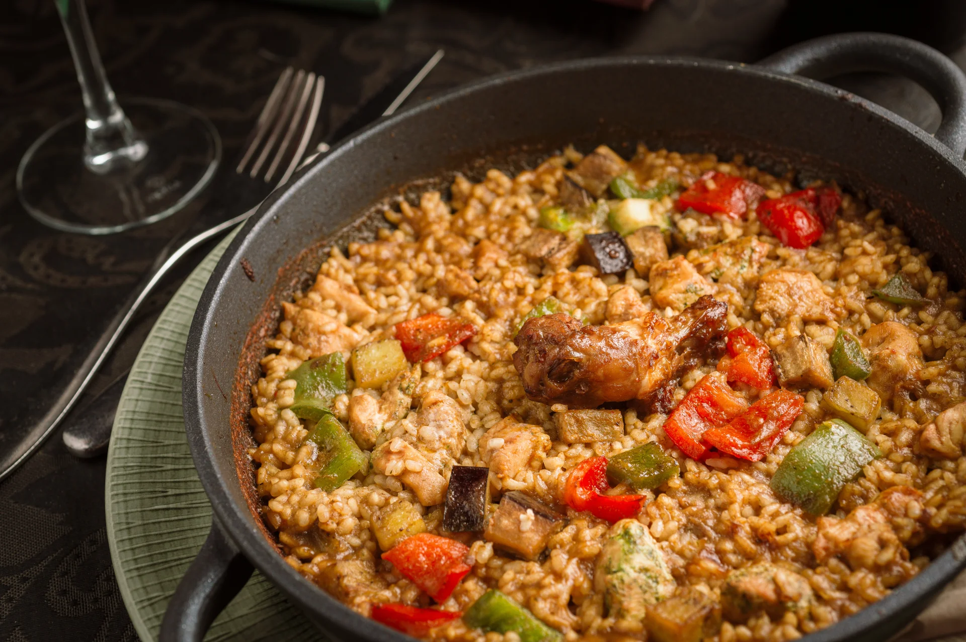 Detail of the ingredients of a chicken and vegetable paella with rice, chicken and fresh vegetables